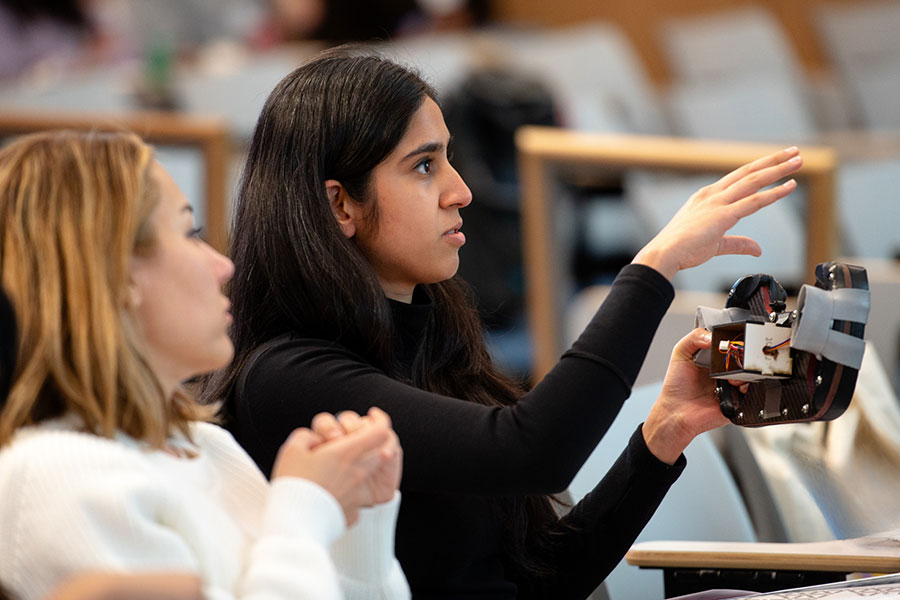 student holds a prototype at an event
